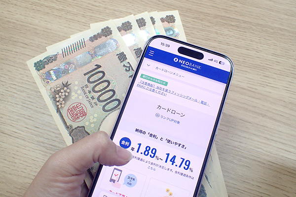 住信SBIネット銀行カードローンの公式HPを表示させたスマホとお金